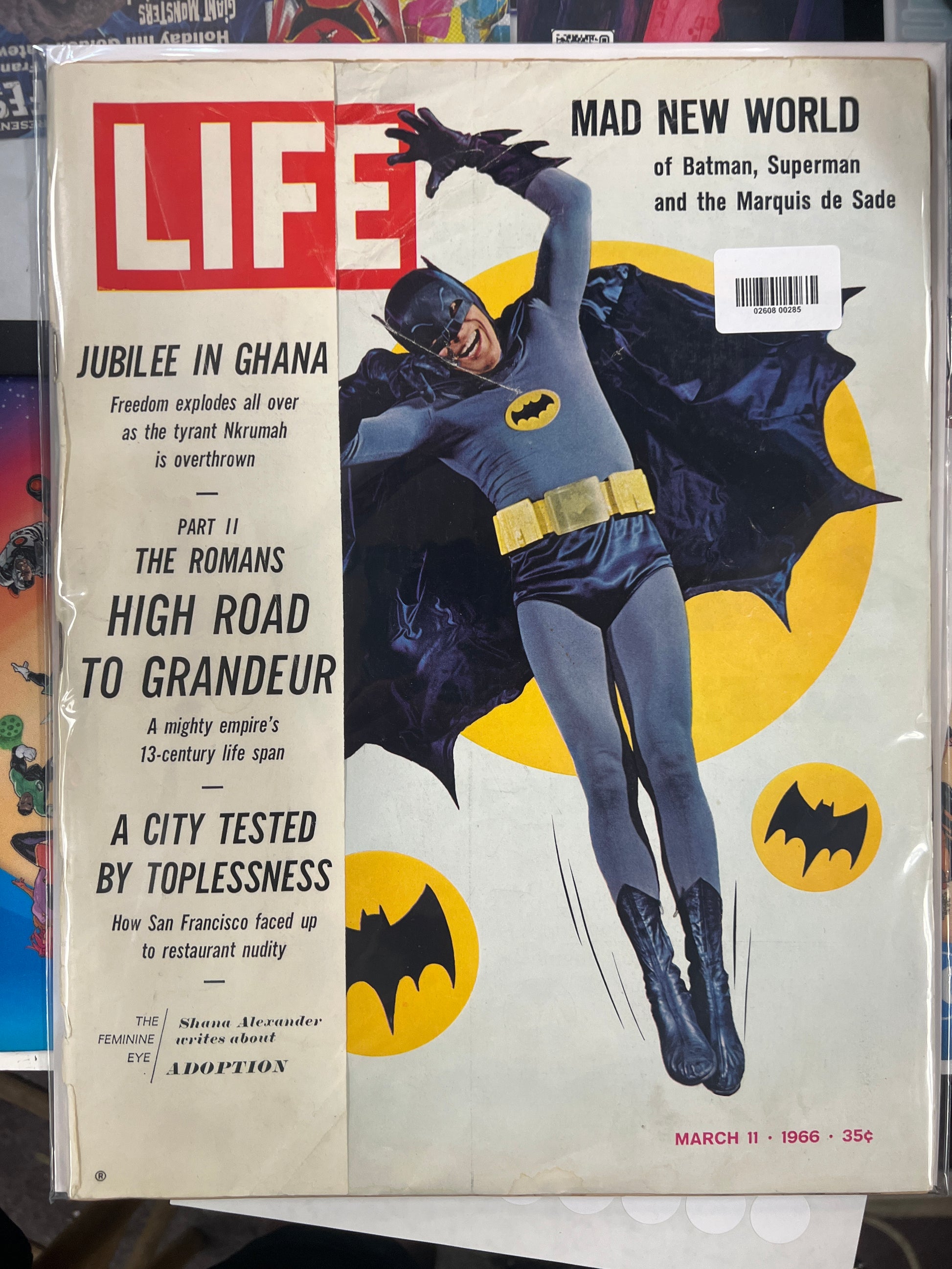 A vintage March 1966 issue of Life magazine featuring Batman on the cover, displayed flat against a background of other books or magazines.